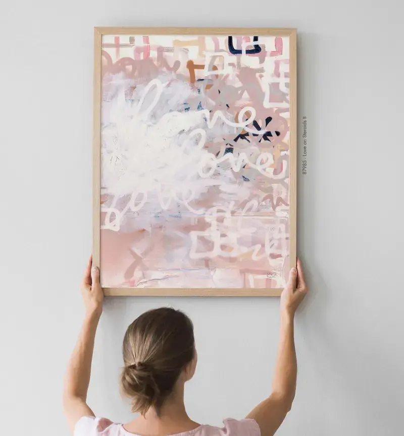 Mujer colgando un cuadro abstracto